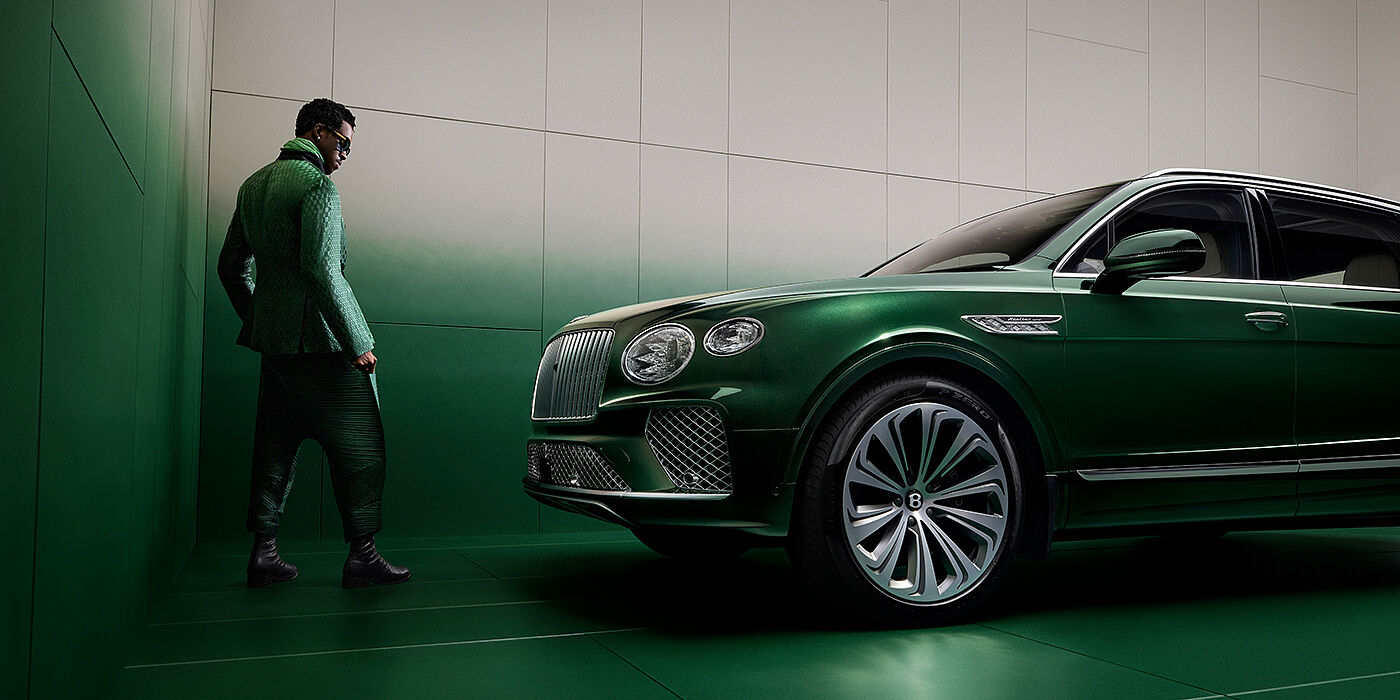 Bentley New Delhi Wisdom K standing next to Bentley Bentayga Extended Wheelbase SUV in Light Emerald green paint in profile