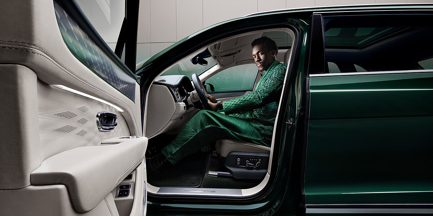 Bentley New Delhi Wisdom K seated in Bentley Bentayga Extended Wheelbase SUV in Light Emerald green paint with door open